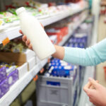 Потребител проверява млечен продукт в магазин към новината за санкциите за заблуждаващо масло