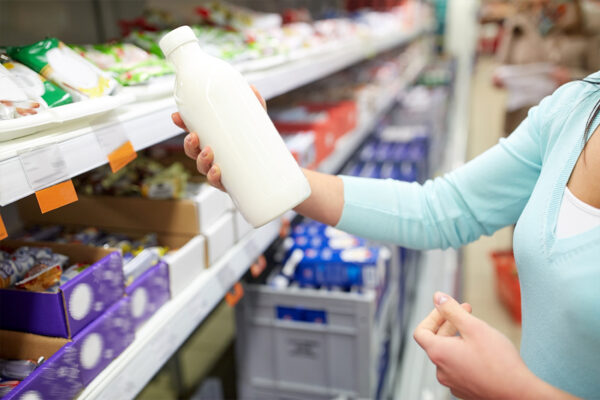 Потребител проверява млечен продукт в магазин към новината за санкциите за заблуждаващо масло