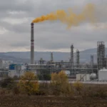 Илюстрация на промишлен комин с жълто-оранжев облак при аварийно изпускане