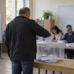 Избирател пуска бюлетина в прозрачна урна на президентските избори през 2026 г.