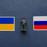 Знамена на Украйна и Русия с военна фигура между тях – илюстрация към новината за ударите