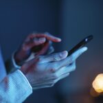 Млад човек използва смартфон, илюстрация към дебата за социалните мрежи и децата